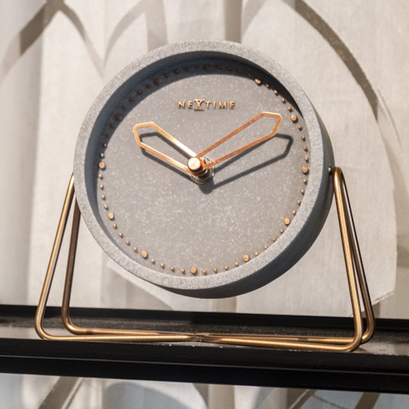 NeXtime Clocks table clock in polyresin, featuring a compact design with a clear clock face, measuring 17.5 x 15.5 x 5 cm.