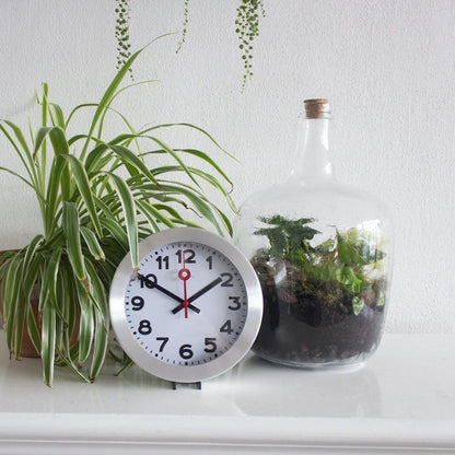 NeXtime Clocks aluminum wall or table clock with station number design, featuring a modern, minimalist style.