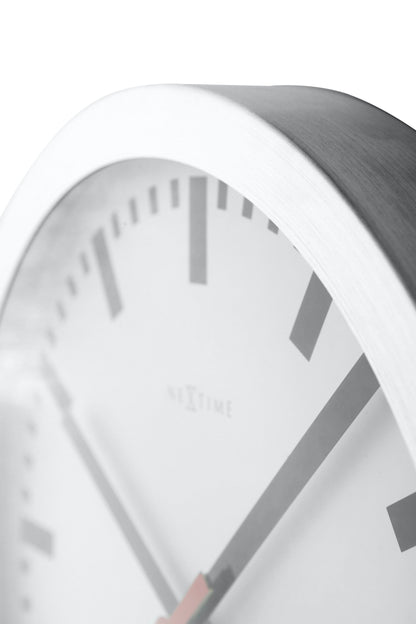 NeXtime Clocks Station Stripe aluminum wall or table clock with modern design and detailed face in the image.