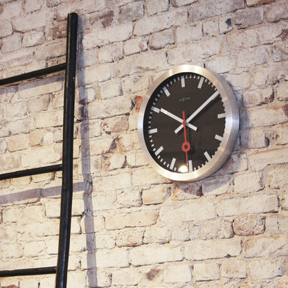 Black aluminum NeXtime Station Stripe wall or table clock with a sleek design and modern appearance.
