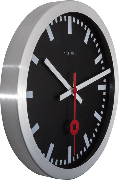 NeXtime Clocks black aluminum Station Stripe wall or table clock with minimalist design, showing the clock face and hands.
