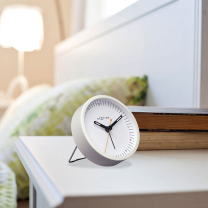 Small NeXtime metal table alarm clock with light function, silent operation, measuring 9x9x7.5cm, on a neutral background.