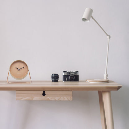 NeXtime Clocks Berlin table alarm clock, silent metal design, 14x13x7cm, placed on a desk or surface, modern and sleek style.