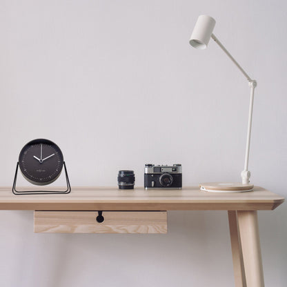 NeXtime Clocks Berlin Table Alarm Clock, silent metal design, 14x13x7cm, placed on a desk with a modern atmosphere.