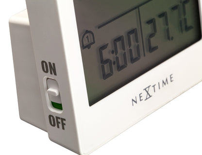 Close-up of NeXtime Digital Table Alarm Clock showing time display and alarm setting buttons on a compact white clock.