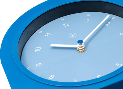 NeXtime Swing Table Clock in black plastic, 30x20 cm, with a modern design, displayed on a table.