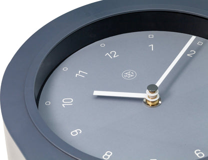 Plastic Swing Table Clock by NeXtime Clocks, 30x20 cm, with a modern design and detailed clock face on a wooden surface.